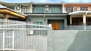 A residential building with a gated entrance, a visible door, and a balcony.