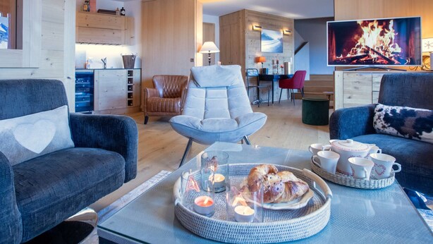 A modern living room with a sofa, armchair, and dining area. - Villars Soleil B 13/14 by Interhome (Villars)