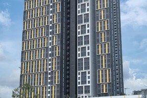 A high-rise building with a grid-like facade and multiple windows. - Chill Lah Homestay (Iskandar Puteri)