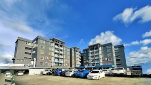 A multi-story hotel with a parking lot in front. - EMART HOTEL RIAM SDN BHD (Miri)