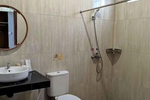 Ein Badezimmer mit einem weißen Waschbecken, einer Toilette und einer Dusche mit Duschbrause.