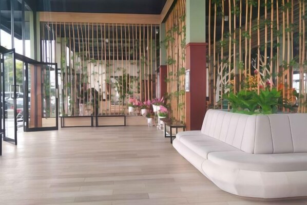 Relax on a white leather sofa against a natural backdrop of bamboo-like panels.