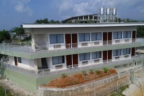 Un immeuble à plusieurs étages, doté de balcons, d’un toit plat et d’un réservoir d’eau situé sur le toit.
