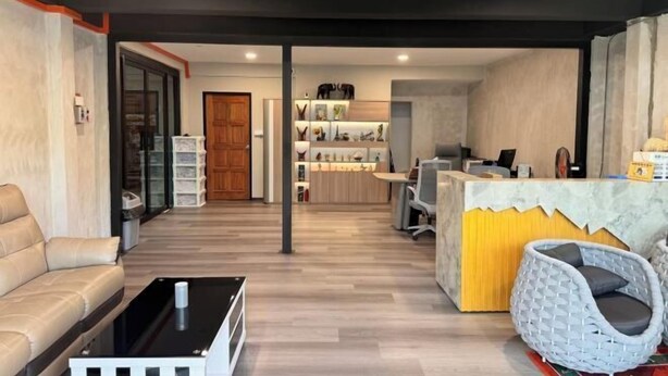 A modern hotel lobby with a reception desk, seating area, and a visible staircase. - Peaceful Cottage (Semporna)