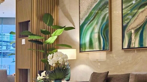 Un interior moderno con un sofá, una planta decorativa y arte abstracto en la pared.