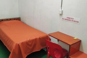 A single-bed room with a 'Strictly No Smoking' sign, a wooden desk, and a red chair. - Wisma Orchid Homestay Tuaran (Tuaran)
