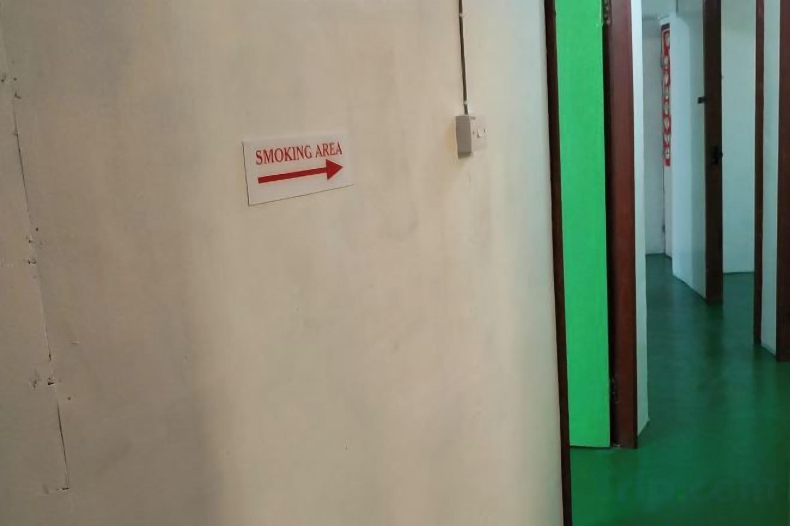 A hallway with a sign indicating a smoking area.