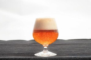 A glass of beer on a textured surface.