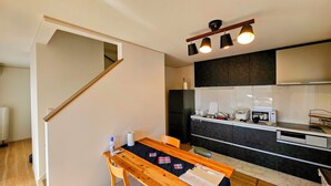 Eine moderne Küche mit Essbereich, einer Treppe und einer Mikrowelle.