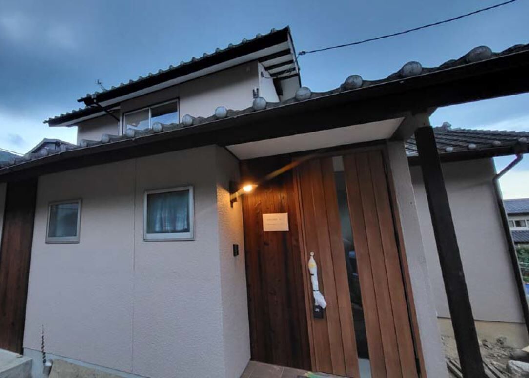 A building with a tiled roof, a wooden door, and a small window.