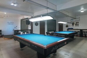 A pool table with a Star Billiards logo, a clock on the wall, and a speaker. - RedDoorz @ Western Bicutan Transients Inn (Taguig)