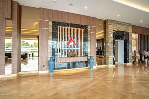 En rummelig lobby med reception, store vinduer og moderne design.