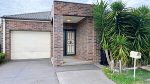 A residential house with a garage, a decorative door, and a mailbox.