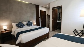 A hotel room with a large bed, bedside tables, a desk, and a bathroom visible through an open door. - Coron 180 Hotel (Coron)