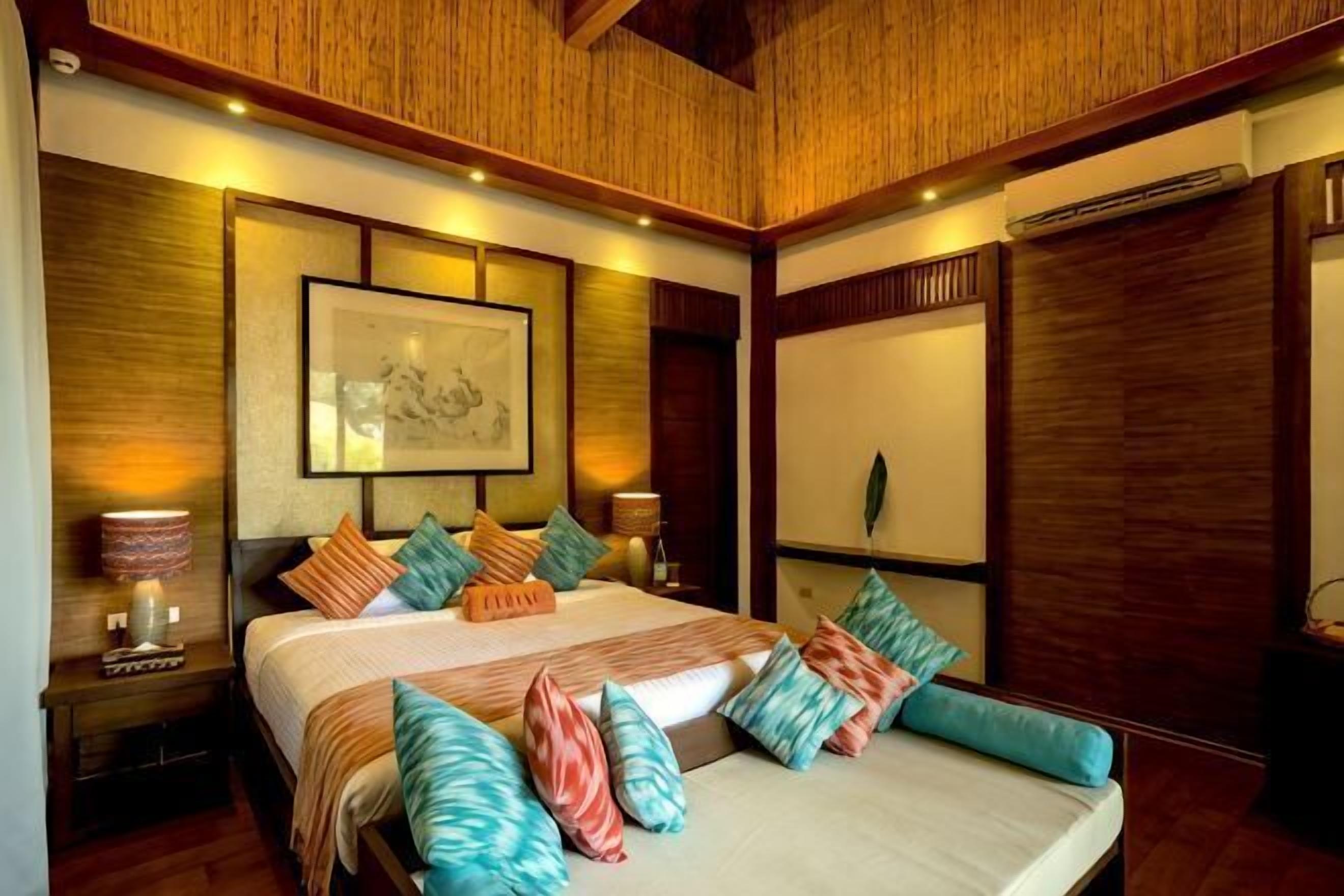 A bedroom with a large bed, wooden headboard, and a framed picture on the wall.