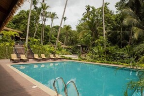 A swimming pool with lounge chairs and a wooden deck. - Lihim Resorts (El Nido)