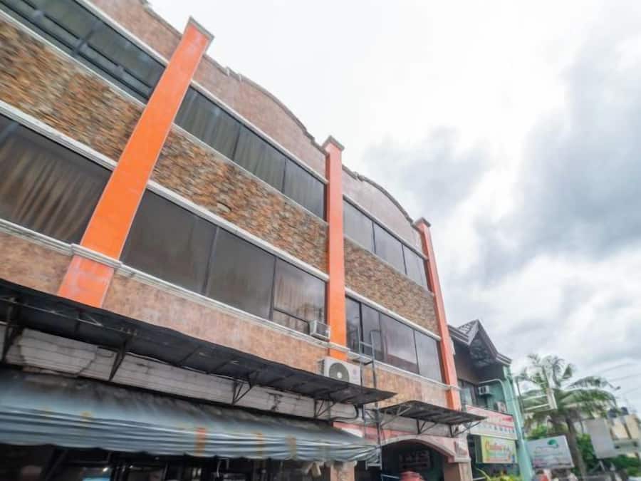 A multi-story building with a brick facade and orange structural columns.