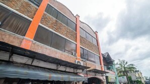 Un immeuble à plusieurs étages, doté d’une façade en briques et de grandes fenêtres.