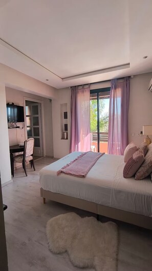 A bedroom with a bed, a desk, and a chair. There is a window with curtains and a view of greenery outside. - Stunning villa with a private pool and a playhouse for children (MX62+8Q6 (ref GPS))