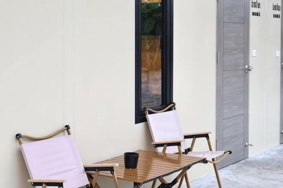 Une table avec deux chaises, une fenêtre et une porte.