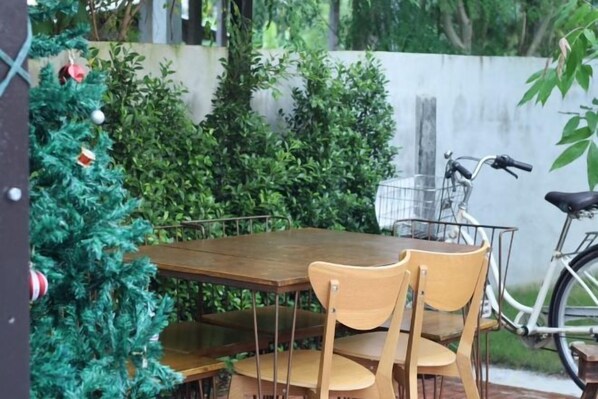 Une table en bois avec des chaises, un vélo et un sapin de Noël.