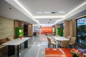 Un moderno vestíbulo de hotel con una zona de estar central, una recepción y vistas a la ciudad.