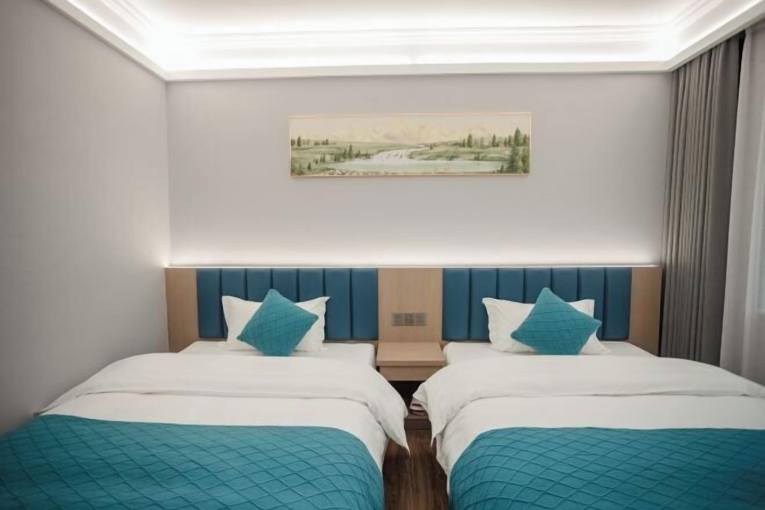 A hotel room with two beds, a painting on the wall, and a nightstand between them.
