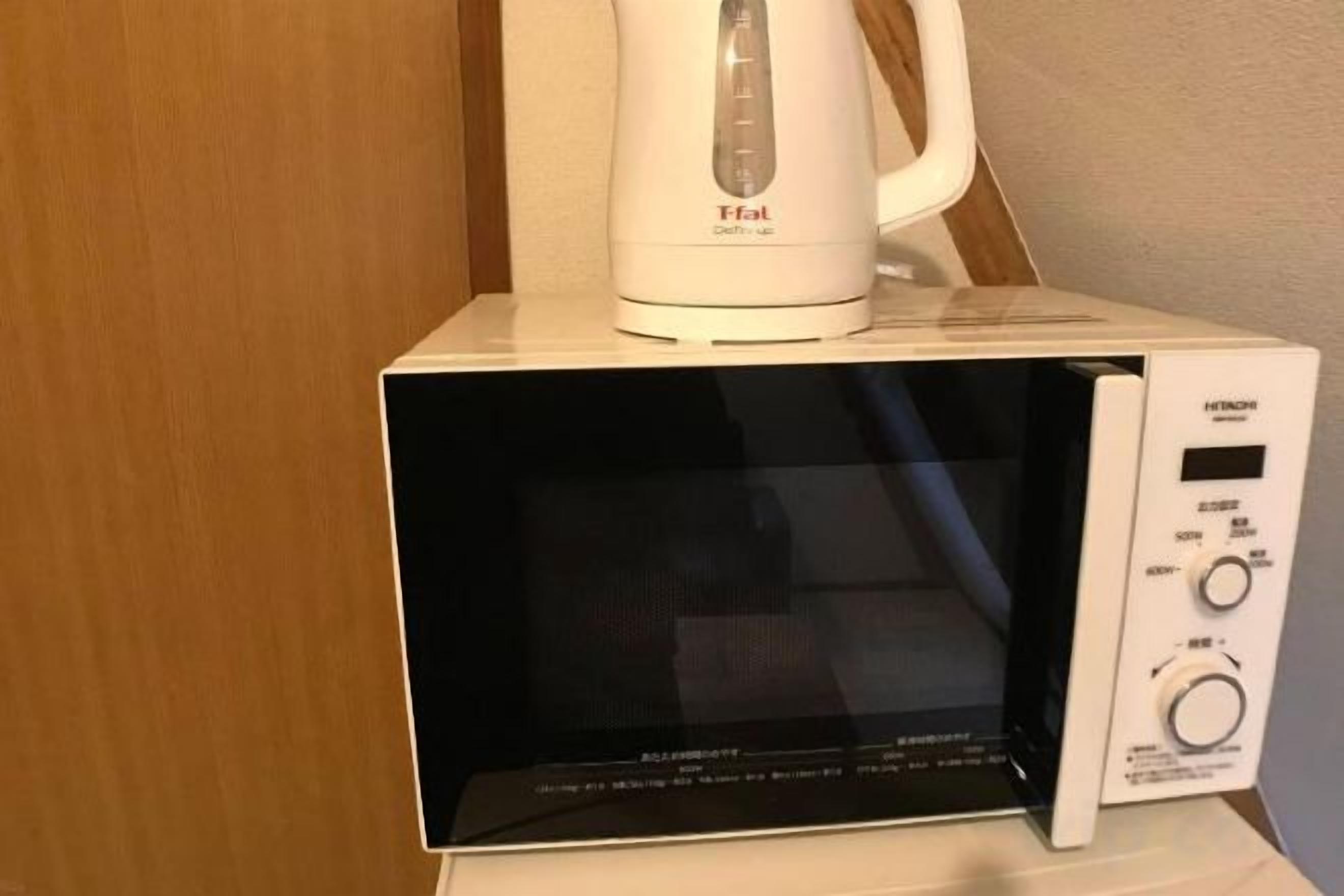 Un four à micro-ondes doté d’un écran numérique et d’un panneau de commande, posé sur une surface blanche.