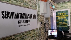 A reception area with a sign for 'SEAWIND TRAVEL SDN. BHD.' and a computer monitor displaying a room. - Cow B Homestay Semporna (Semporna)