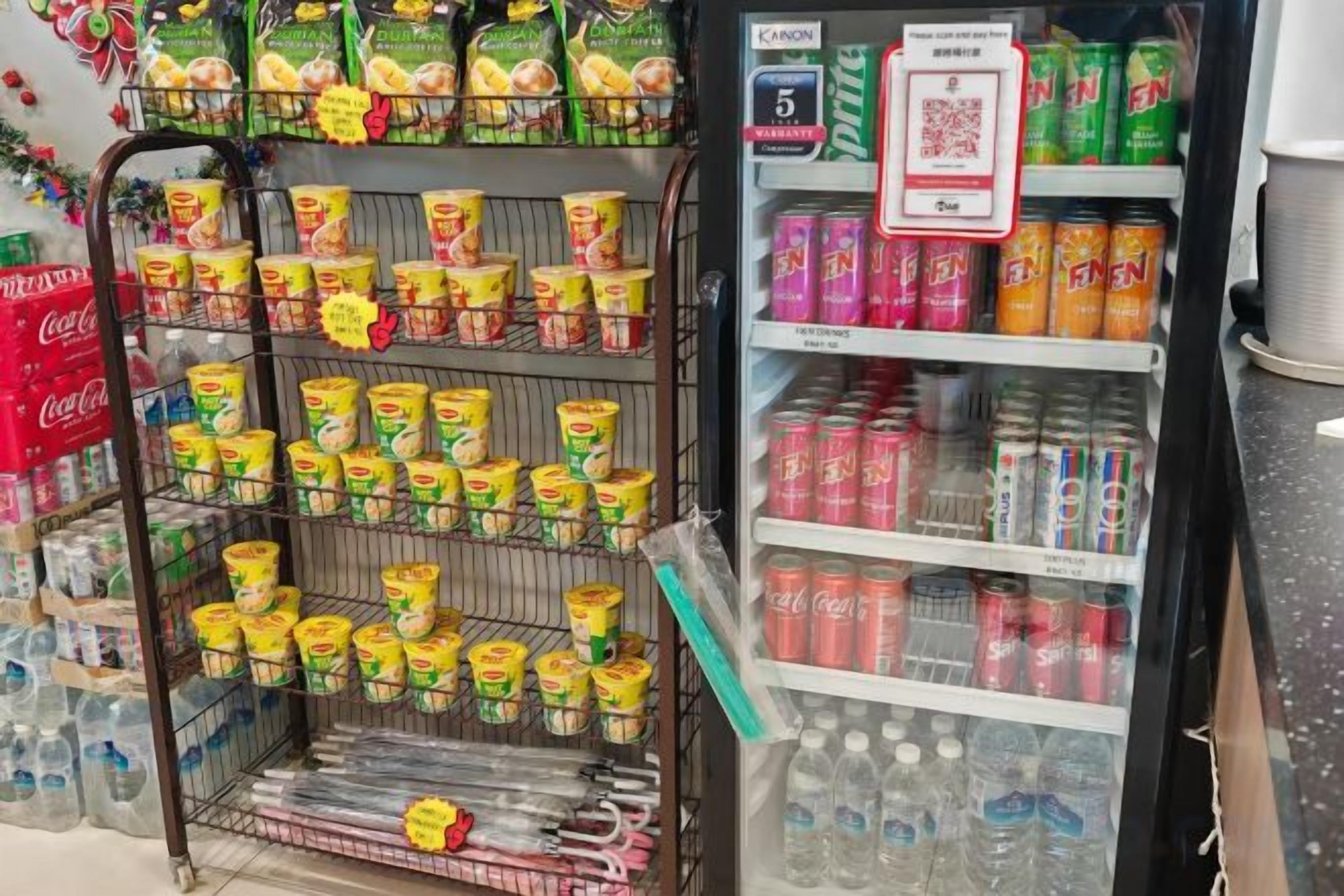 Mostrador refrigerado con diversas bebidas y aperitivos.