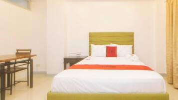 A hotel room with a bed, a desk, and a chair.