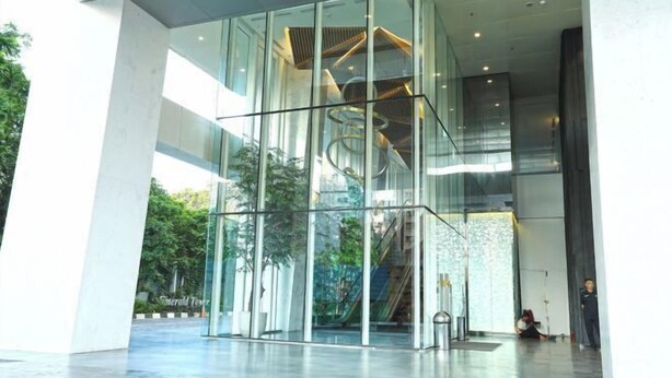 Een modern gebouw met een glazen gevel, een wenteltrap en een ruime lobby.