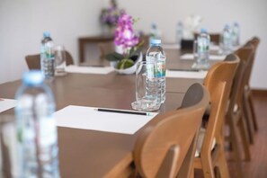 A conference table with chairs, water bottles, and a vase with flowers.