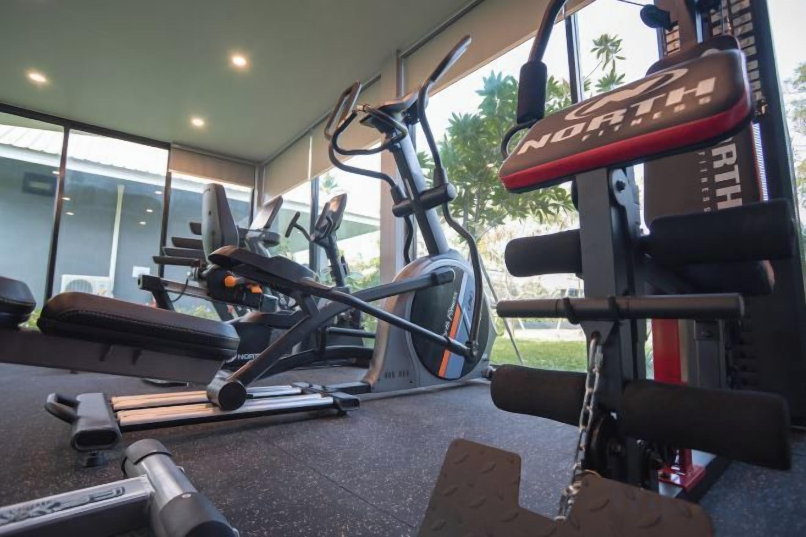A gym with exercise equipment including a treadmill, stationary bike, and weight machines.