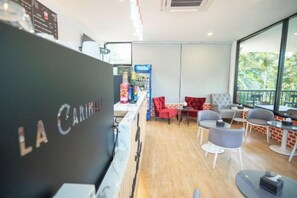 Ein modernes Interieur mit einer Rezeption, einer Sitzecke und großen Fenstern.