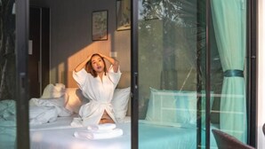 A bedroom with a bed, a window, and a view of trees. - Seeview Resort (Phetchabun)