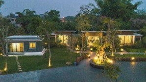 A modern house with a well-maintained lawn and a small pond. - Seeview Resort (Phetchabun)