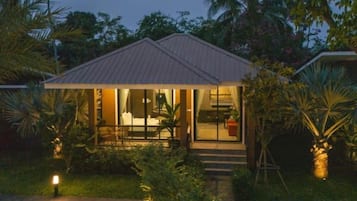 A house with a covered porch, a visible interior with a dining area, and a well-lit entrance.