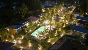 An aerial view of a resort with multiple buildings, a swimming pool, and well-lit pathways. - Seeview Resort (Phetchabun)