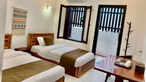 A room with two beds, a wooden table with a tray, and a wall-mounted air conditioner. - Happy Hour Boutique​ Hotel (Luang Prabang)