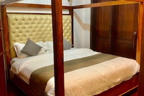 A four-poster bed with a tufted headboard, white bedding, and a wooden frame. - Happy Hour Boutique​ Hotel (Luang Prabang)