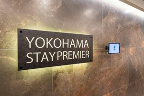 Um letreiro na parede com a inscrição 'YOKOHAMA STAY PREMIER'.
