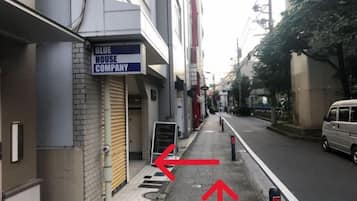 A narrow urban street with a building labeled 'BLUE HOUSE COMPANY' on the left.
