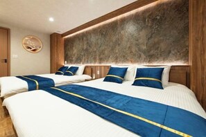 Een hotelkamer met twee bedden, een houten hoofdbord en een ronde wandversiering.