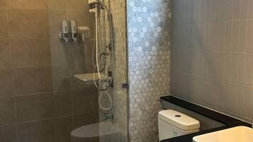 Un bagno moderno con doccia vetro, WC e lavabo.