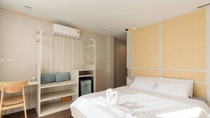 A hotel room with a bed, a desk, a wardrobe, and an air conditioning unit. - Jaidee Pool Villa (Hat Yai)
