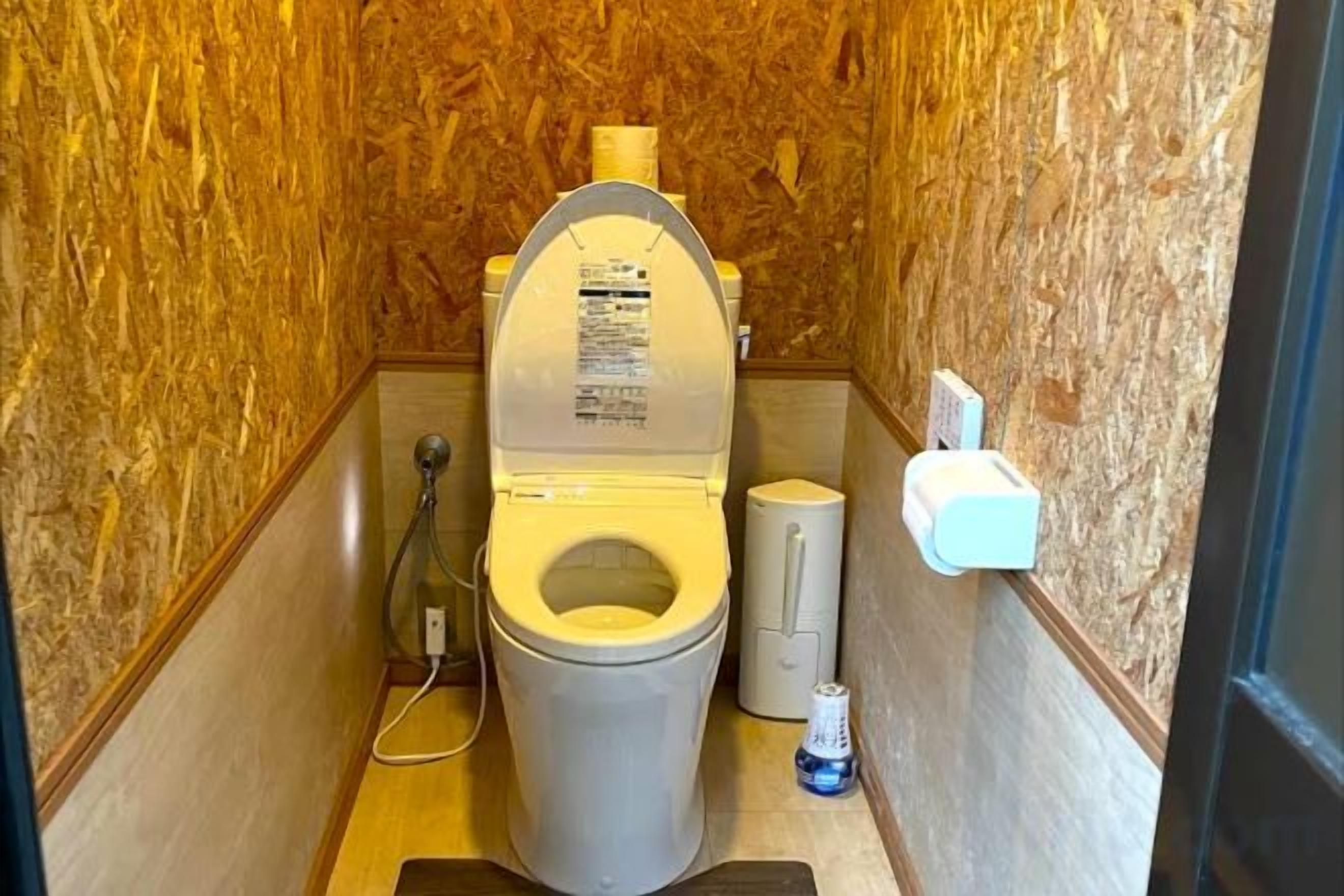 Une petite salle de bain compacte, équipée de toilettes, d’un bidet et d’un sèche-mains.
