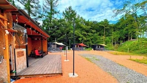 A wooden building with a deck, surrounded by trees and a gravel path. - Bulls Camp -Guesthouse with pets at the foot of World Heritage Mt.Fuji- (Narusawa)