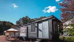 A mobile camping unit with a large sign, a covered seating area, and a gravel ground. - Bulls Camp -Guesthouse with pets at the foot of World Heritage Mt.Fuji- (Narusawa)