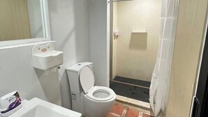 A bathroom with a toilet, sink, and shower curtain. - Shi-ro-i Poshtel (Hat Yai)